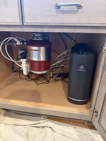 The Sanavia Hydra in place in a under-sink cabinet, with the drain lines run neatly to one side